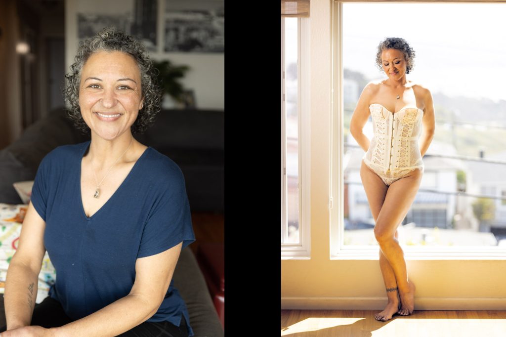 A before & after image from a boudoir photo shoot after weight loss. This comparison features a woman with curly silver hair in soft, warm indoor lighting against cozy neutral tones. On the left, she smiles warmly while seated on a gray sofa with hands folded in her lap, dressed in a navy blue V-neck top with a delicate pendant necklace amid potted plants and framed artwork. On the right, she stands relaxed with legs crossed at the ankles, barefoot on wooden floors, wearing a lacy white corset cinched at the waist, her expression effortlessly beautiful beside a sunlit window overlooking urban rooftops in golden afternoon glow.